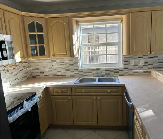 a kitchen with a sink stove and cabinets