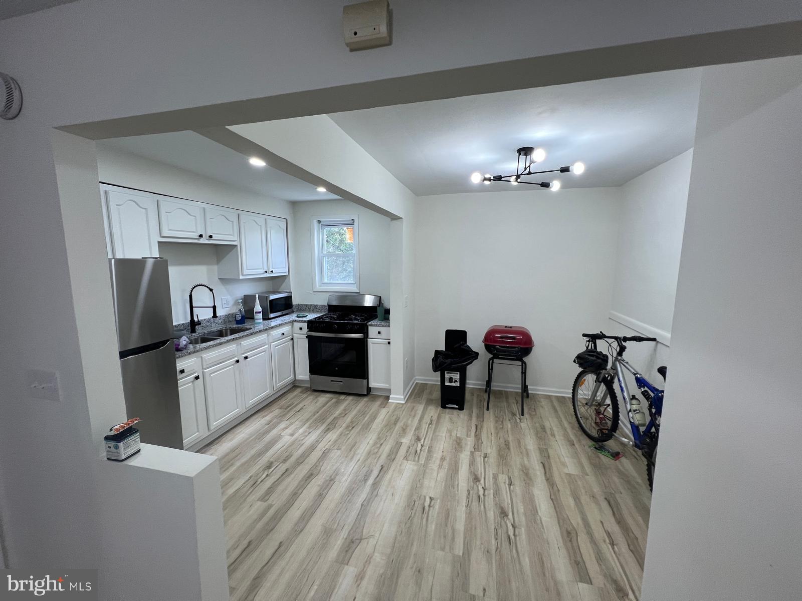 3711 10th Street Baltimore, MD 21225 - Photo 6 of 25 a kitchen with white cabinets and stainless steel appliances