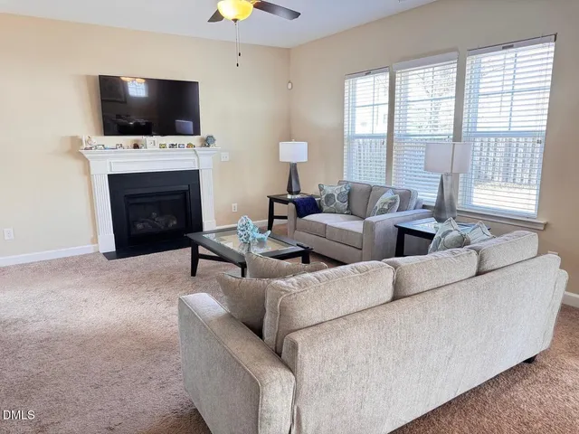 a living room with couches a flat screen tv and a fireplace