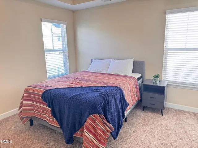 a bed sitting in a bedroom next to a window