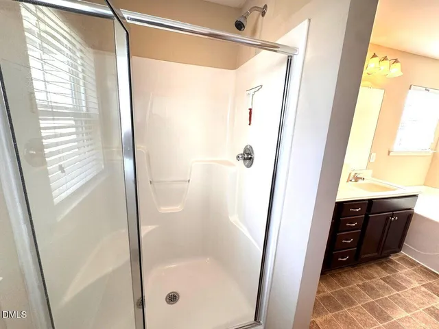 a bathroom with a glass door shower and a sink
