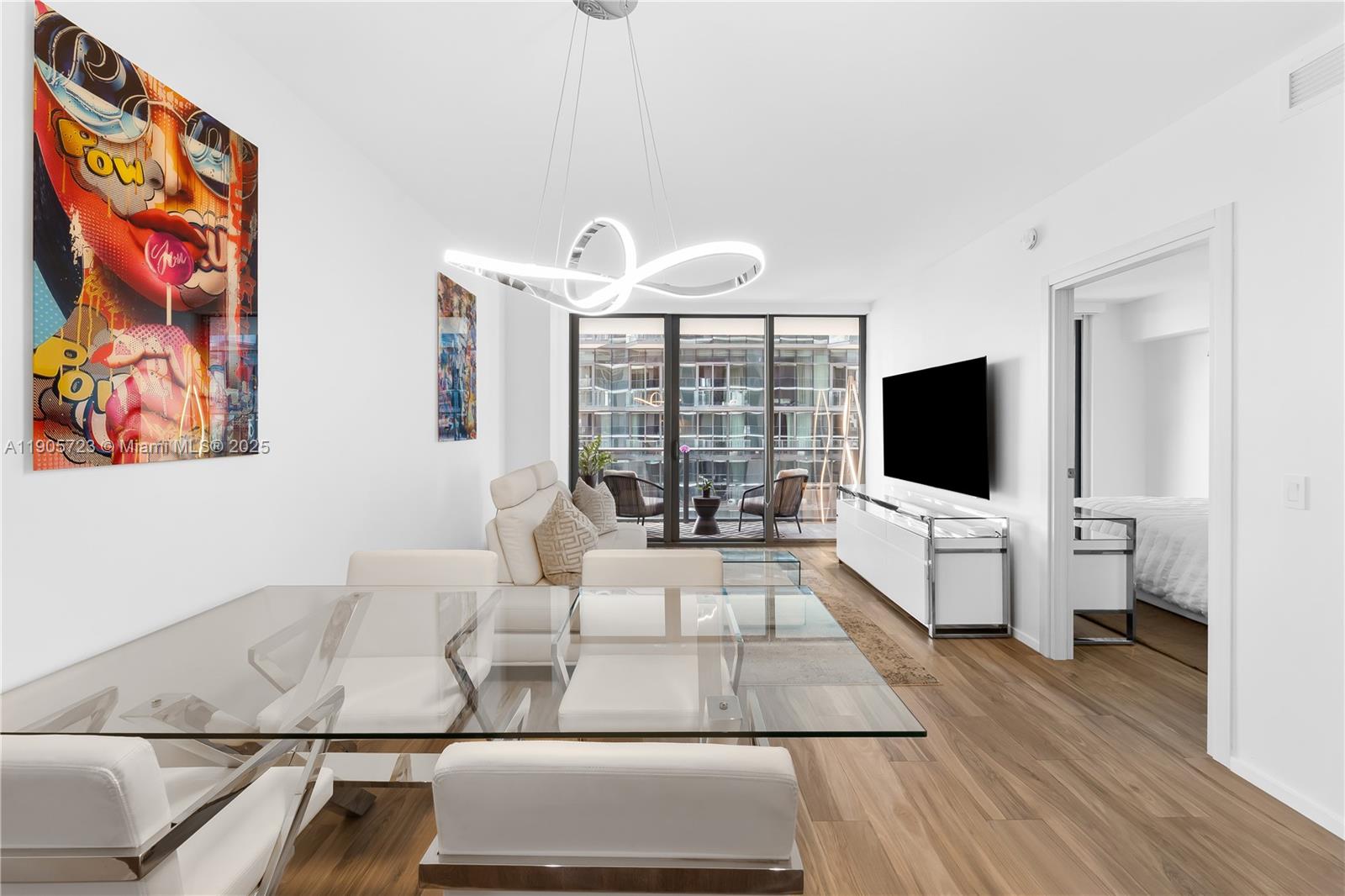 a living room with furniture a flat screen tv and a floor to ceiling window