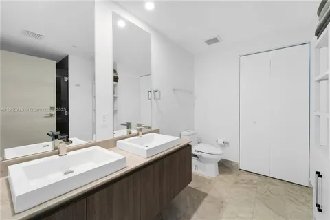a bathroom with a double vanity sink toilet and a mirror