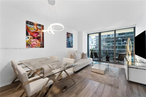 a living room with furniture a flat screen tv and a large window