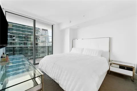 a large bed sitting in a bedroom next to a window