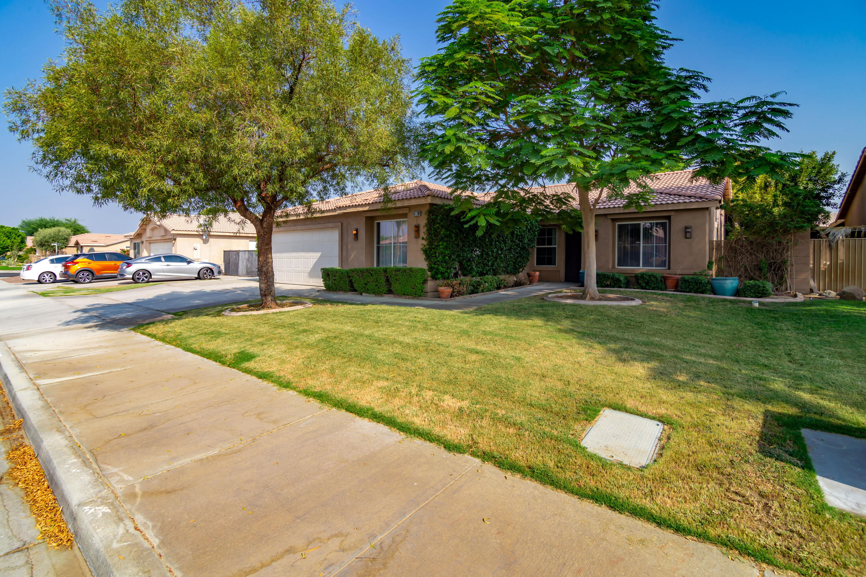 83290 Antigua Drive Indio, CA 92201 - Photo 2 of 31 a view of a house with a yard and garage