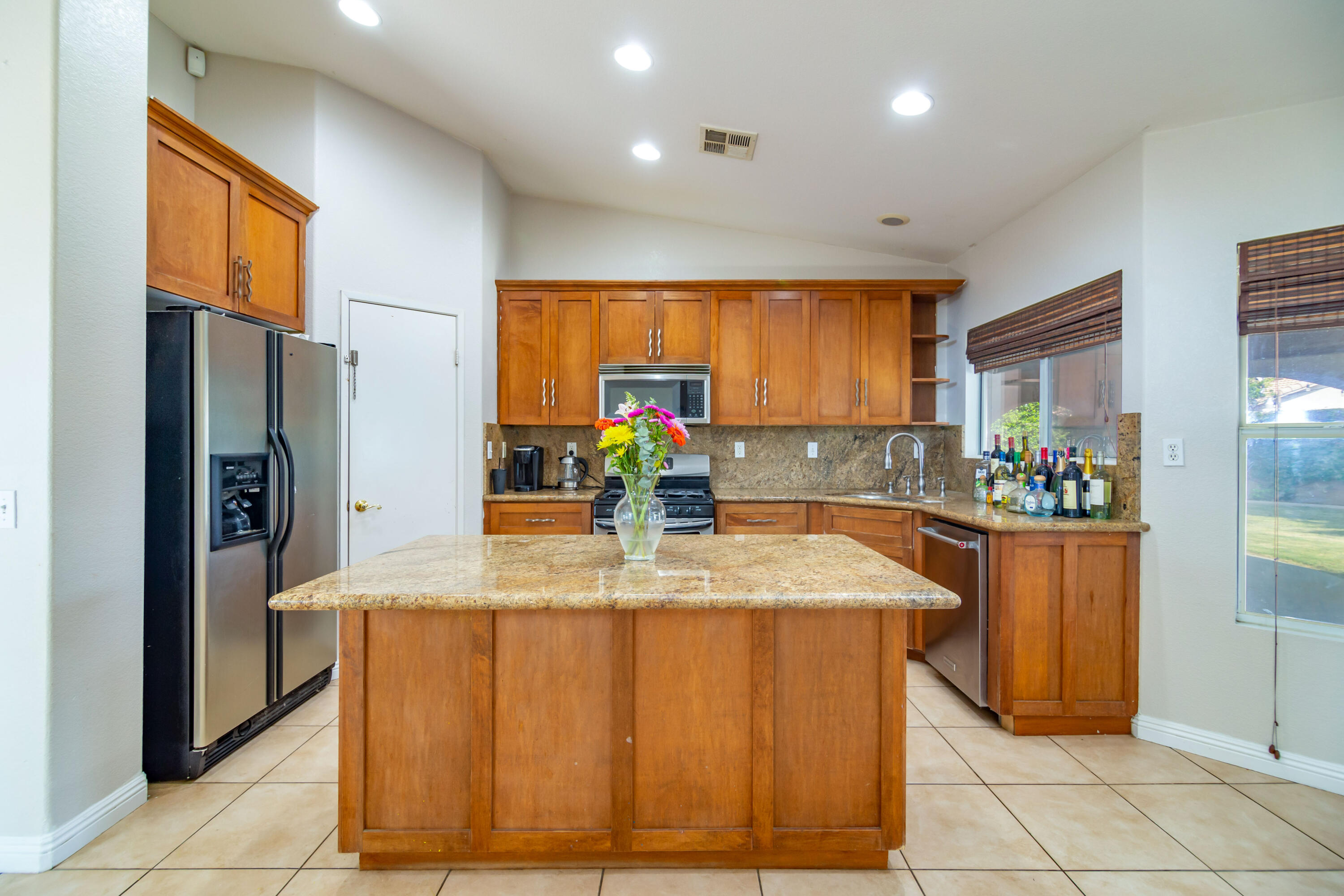 83290 Antigua Drive Indio, CA 92201 - Photo 13 of 31 a kitchen with stainless steel appliances kitchen island granite countertop a refrigerator and a sink