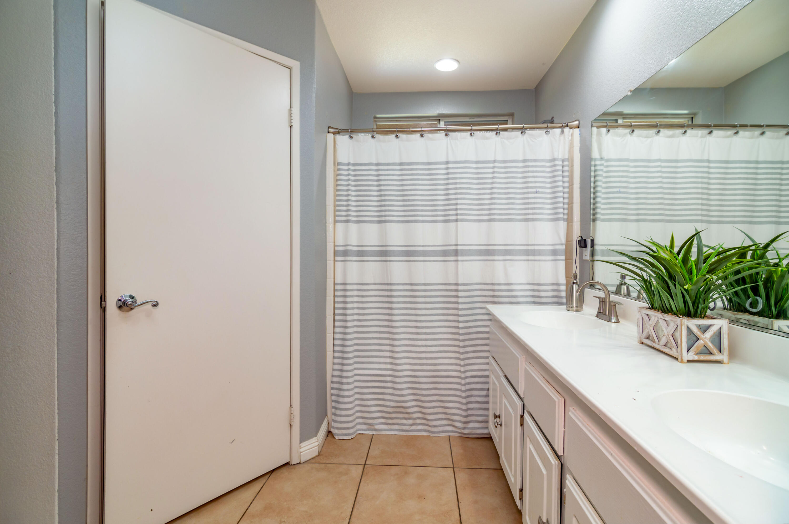 83290 Antigua Drive Indio, CA 92201 - Photo 19 of 31 a bathroom with a granite countertop sink a large mirror and a shower