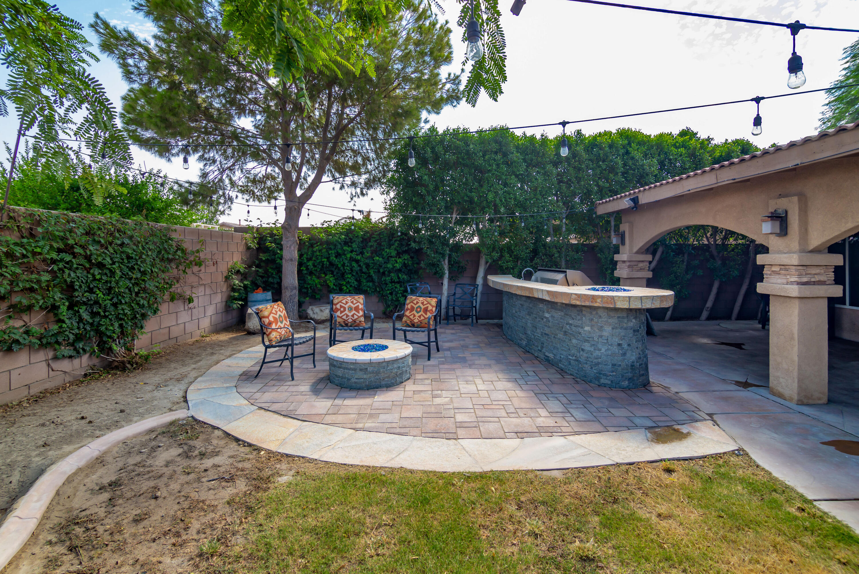 83290 Antigua Drive Indio, CA 92201 - Photo 29 of 31 a view of a backyard with table and chairs potted plants and large tree