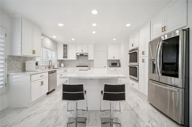 a kitchen with granite countertop a sink and a white cabinets
