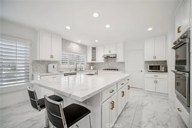 a kitchen with white cabinets and appliances