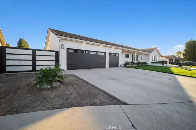a front view of a house with a yard and potted plants