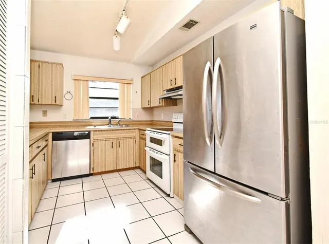 a kitchen with stainless steel appliances a refrigerator sink and cabinets