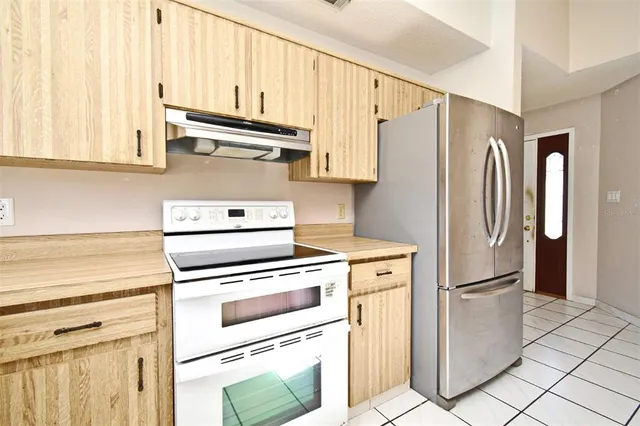 a kitchen with stainless steel appliances white cabinets and a refrigerator