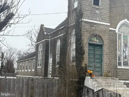 a view of a brick house with a bench next to a yard