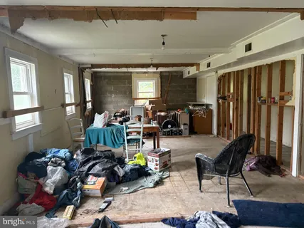 a room with a table chairs and a refrigerator