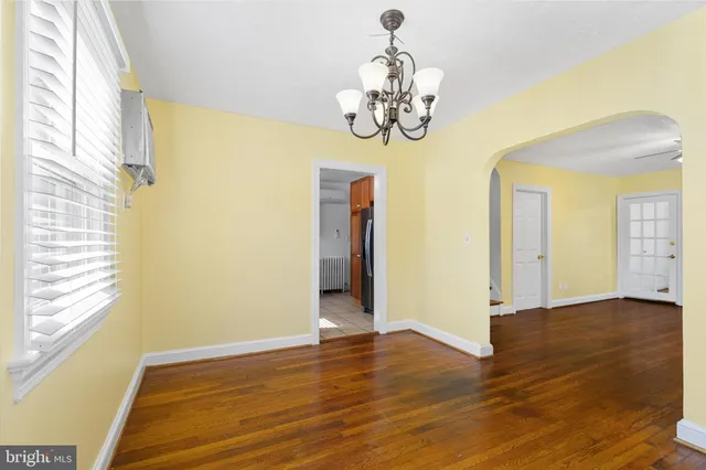 a view of a room with wooden floor and chandelier