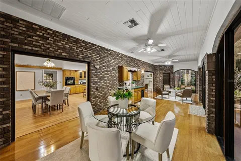 a kitchen with a stove a refrigerator a sink dishwasher with a dining table and chairs with wooden floor