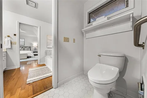 a bathroom with a granite countertop sink a toilet and shower