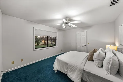 an empty room with wooden floor and a ceiling fan