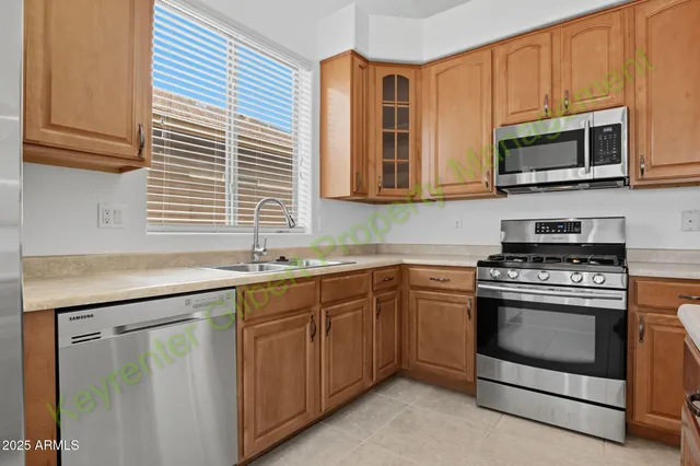 a kitchen with stainless steel appliances granite countertop a stove a sink dishwasher a refrigerator and a dining table with wooden floor