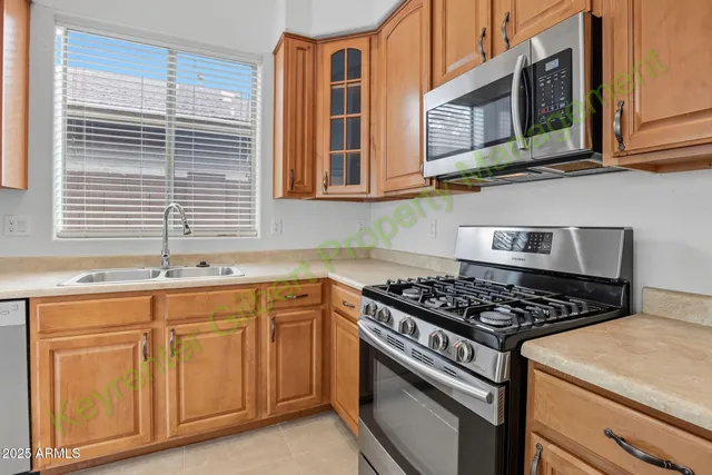 a kitchen with stainless steel appliances granite countertop a stove microwave and sink