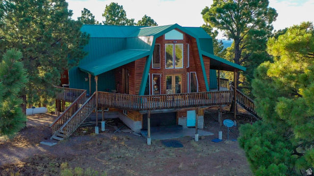 Rear view of house featuring a deck and a metal roof