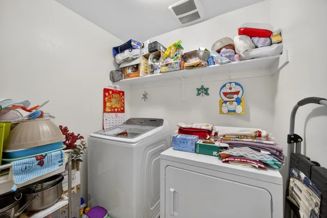 a utility room with lots of clutter and washer
