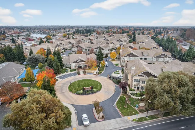 an aerial view of a house with garden space and trees all around