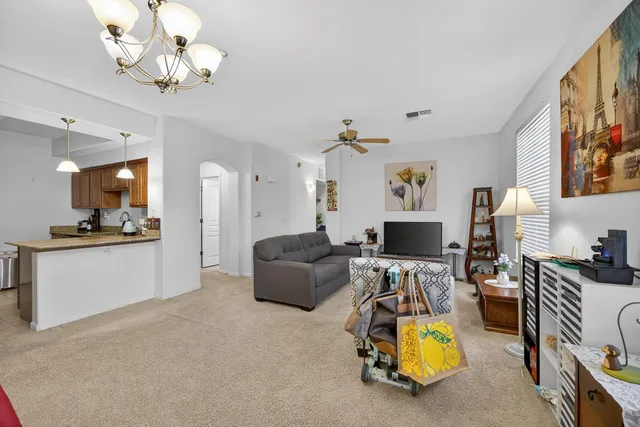 a view of a dining room with furniture a chandelier and wooden floor