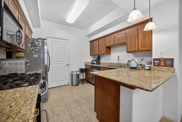 a kitchen with stainless steel appliances granite countertop a sink stove and refrigerator