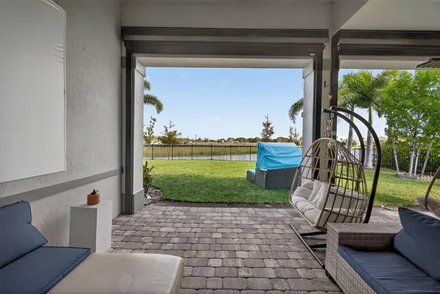 a view of a backyard with swimming pool and sitting area