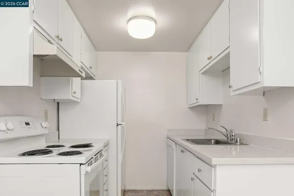 a kitchen with a sink a stove and a refrigerator