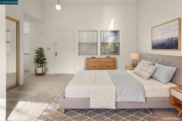 a bedroom with a large bed and a potted plant