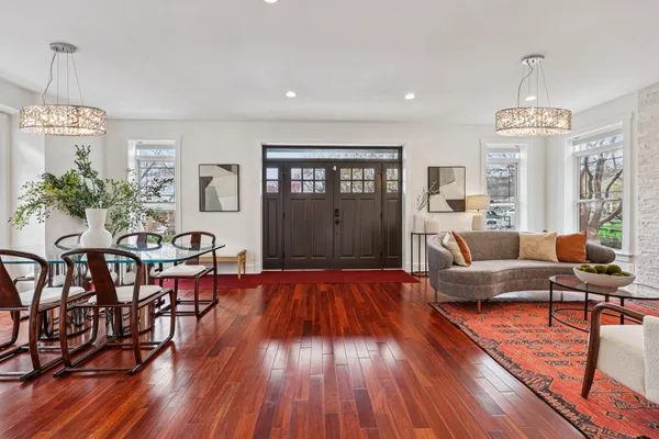 a dining room with furniture a chandelier and wooden floor
