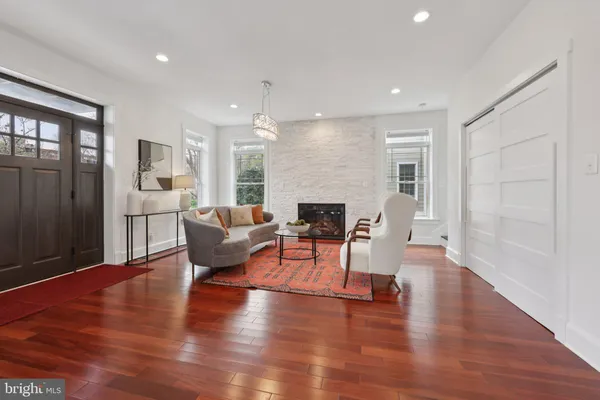 a kitchen with stainless steel appliances granite countertop a stove top oven a refrigerator a dining table and chairs with wooden floor