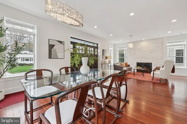 a kitchen with stainless steel appliances kitchen island granite countertop a table chairs sink and cabinets
