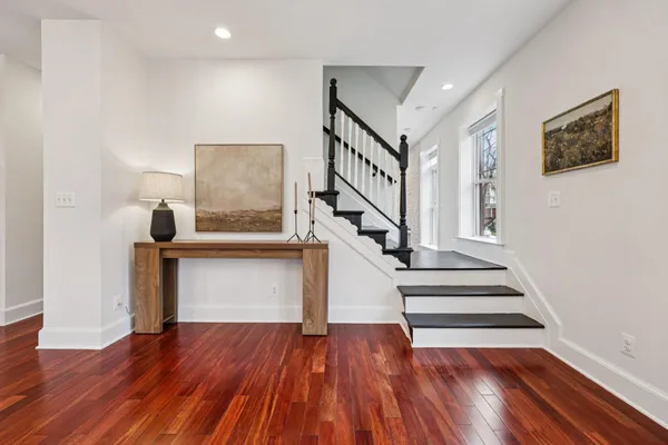 a kitchen with stainless steel appliances kitchen island granite countertop a table chairs and a wooden floor