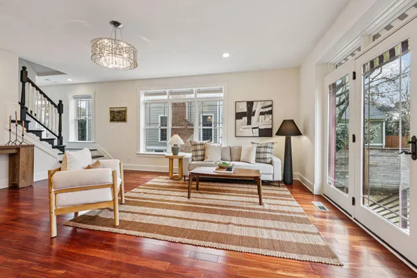 a kitchen with stainless steel appliances granite countertop a stove top oven a sink a dining table and chairs with wooden floor