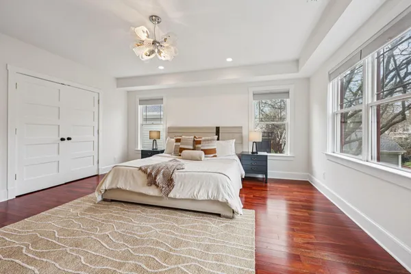 a spacious bedroom with a bed a table with wooden floor