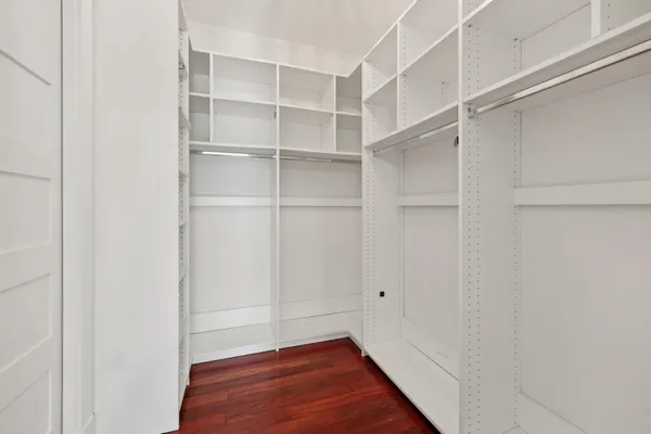 a bedroom with wooden floor and a window