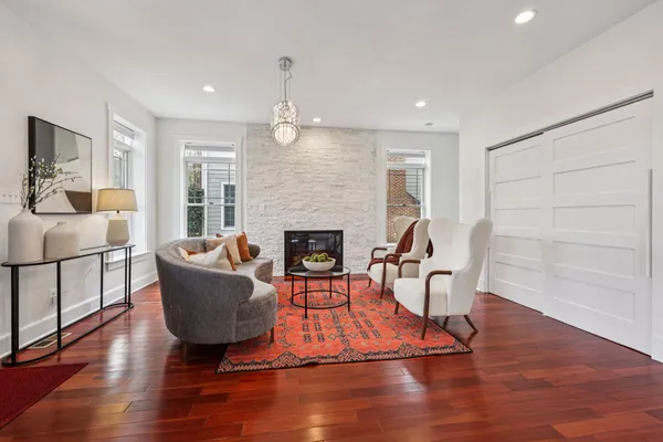 a dining room with furniture a chandelier and wooden floor