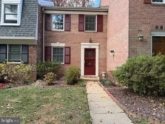 a view of a brick house with many windows plants and large tree