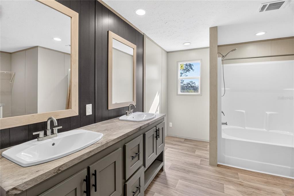 5570 Northeast 76th Avenue High Springs, FL 32643 - Photo 13 of 31 a spacious bathroom with a double vanity sink a mirror and a bathtub