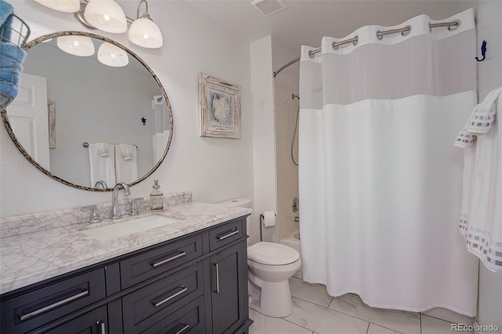 612 Ruby Drive Fort Collins, CO 80525 - Photo 23 of 40 a bathroom with a granite countertop sink mirror vanity and toilet