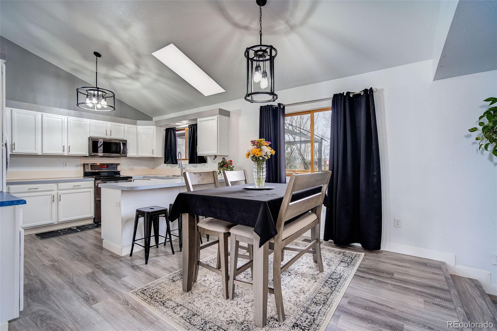 612 Ruby Drive Fort Collins, CO 80525 - Photo 6 of 40 a kitchen with stainless steel appliances kitchen island granite countertop a refrigerator a stove a sink dishwasher and a dining table with wooden floor