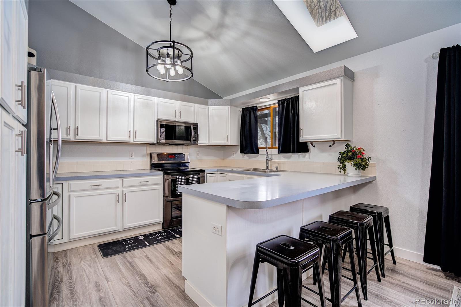 612 Ruby Drive Fort Collins, CO 80525 - Photo 7 of 40 a kitchen with stainless steel appliances granite countertop a stove top oven a sink a dining table and chairs