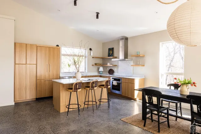 a kitchen with a table chairs a sink dishwasher window and cabinets