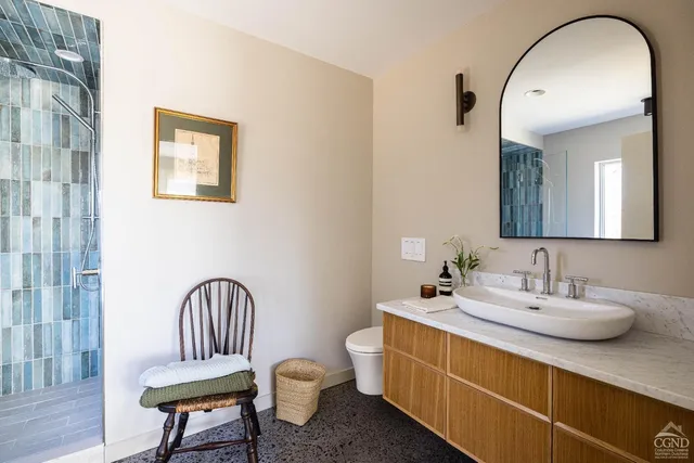 a bathroom with a toilet sink and mirror