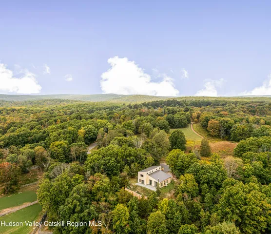 an aerial view of residential houses with outdoor space and trees
